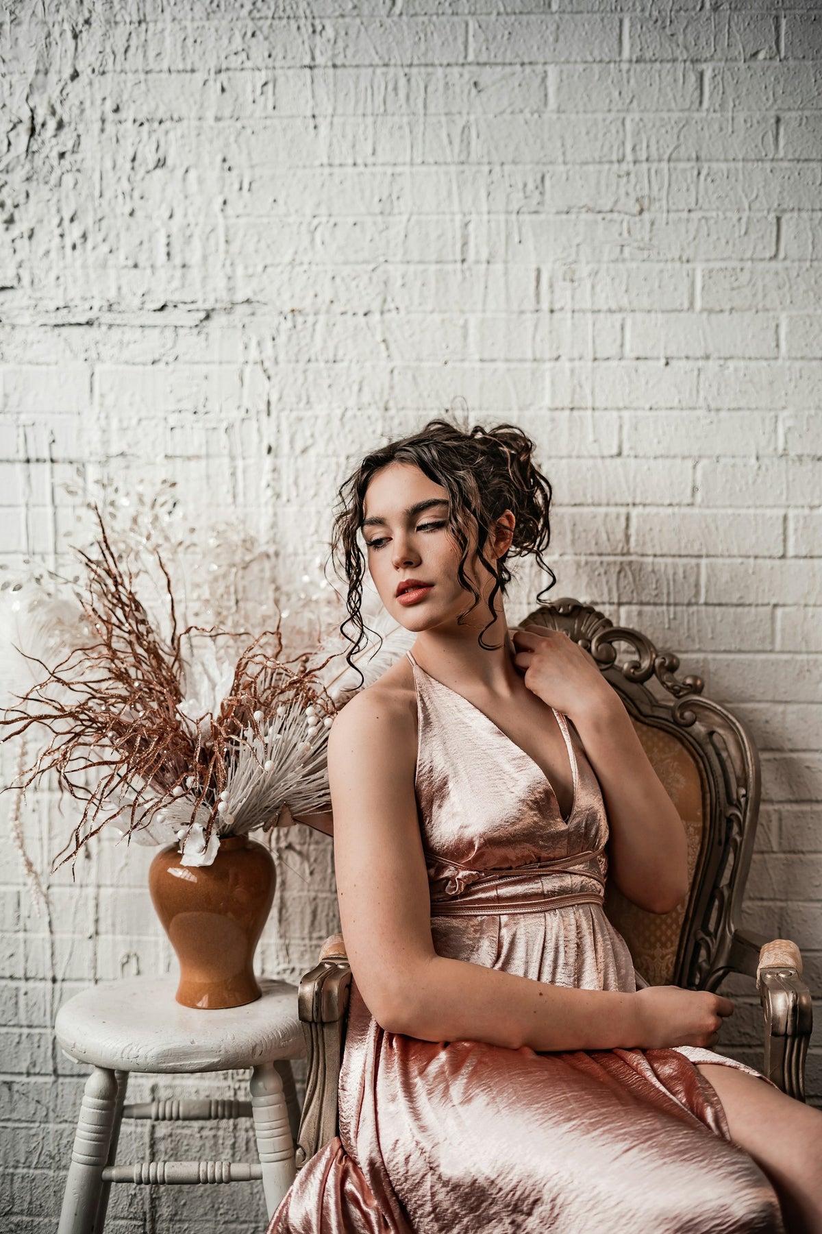Woman seated in a champagne-toned satin dress