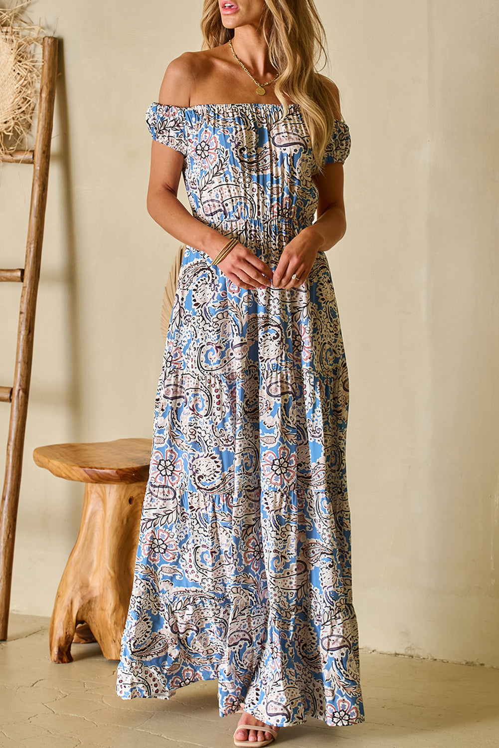 Woman wearing blue floral off-shoulder maxi dress standing outdoors