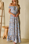 Woman wearing blue floral off-shoulder maxi dress standing outdoors