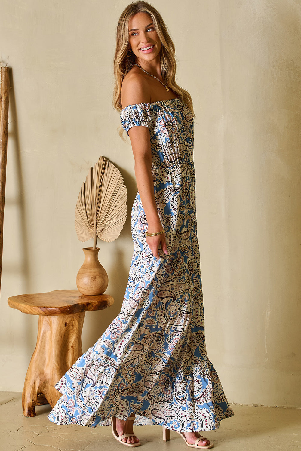 Full-length front view of blue floral off-shoulder maxi dress with model smiling outdoors